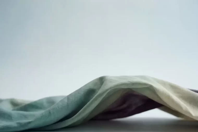 A single gentle wave moving through pale soft cloth