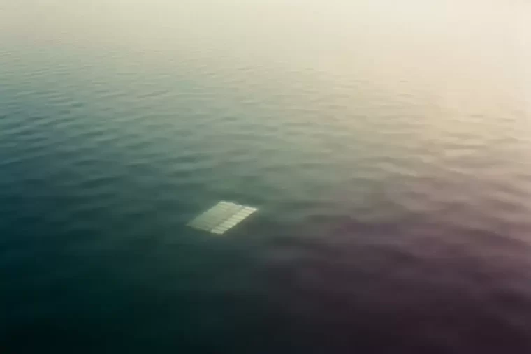 Calm water carrying one clean geometric reflection of light